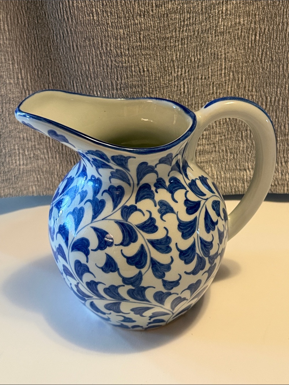 Blue and white 8” pitcher.  Large spout.  Flowing leaves.  Good condition.